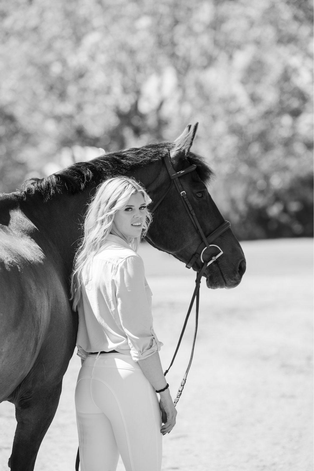 Founder of MKM Sport Horses standing beside a bay sport horse