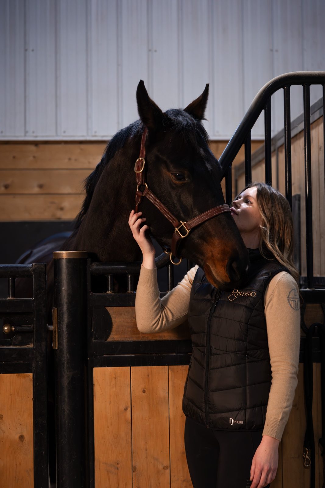 Horse nuzzling handler wearing a physiotherapy vest, representing our rehabilitation partnerships