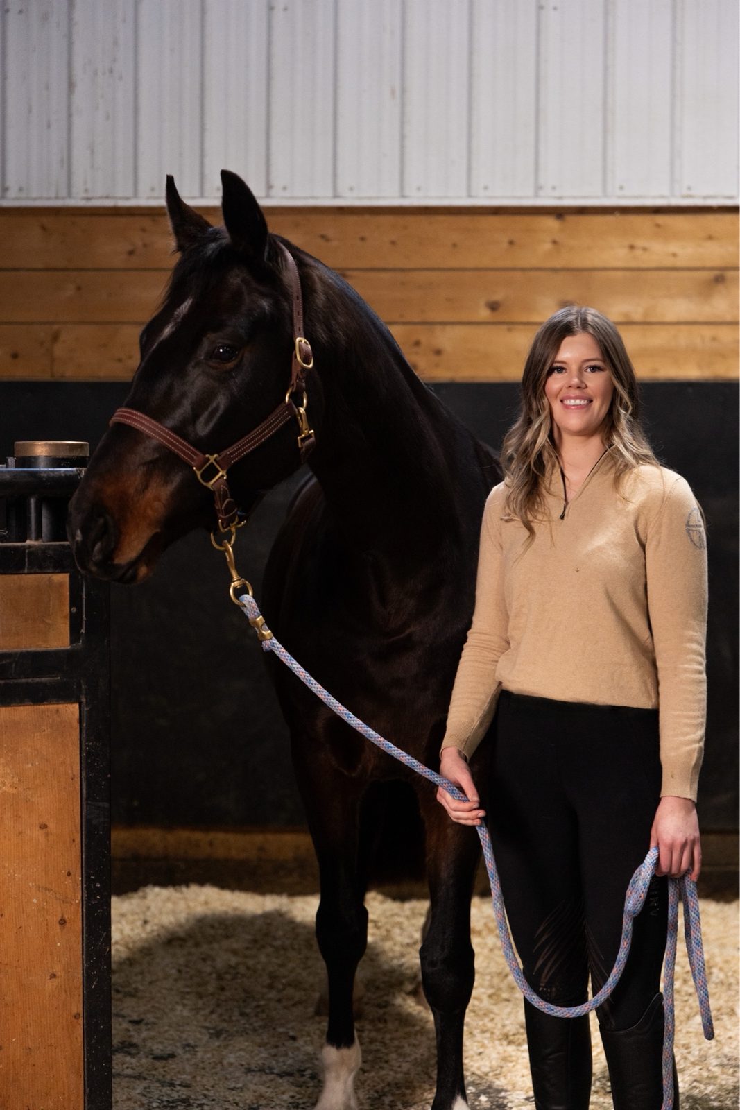Founder standing with a bay horse at the stall door